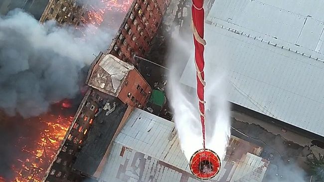 Сброс воды с вертолета Ми-8 Западного военного округа на горящее здание фабрики Невская мануфактура на Октябрьской набережной в Санкт-Петербурге. Кадр видео