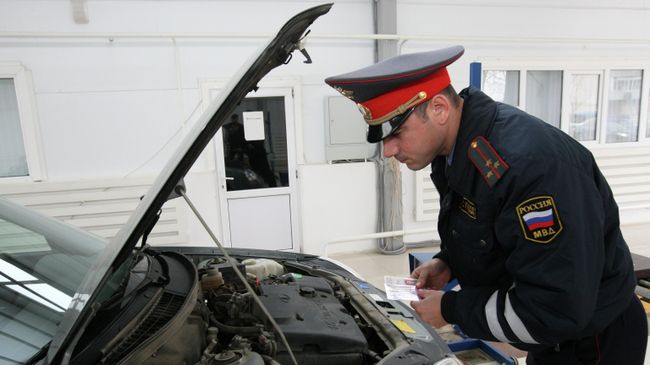 Сотрудник ГИБДД проводит технический осмотр автотранспорта
