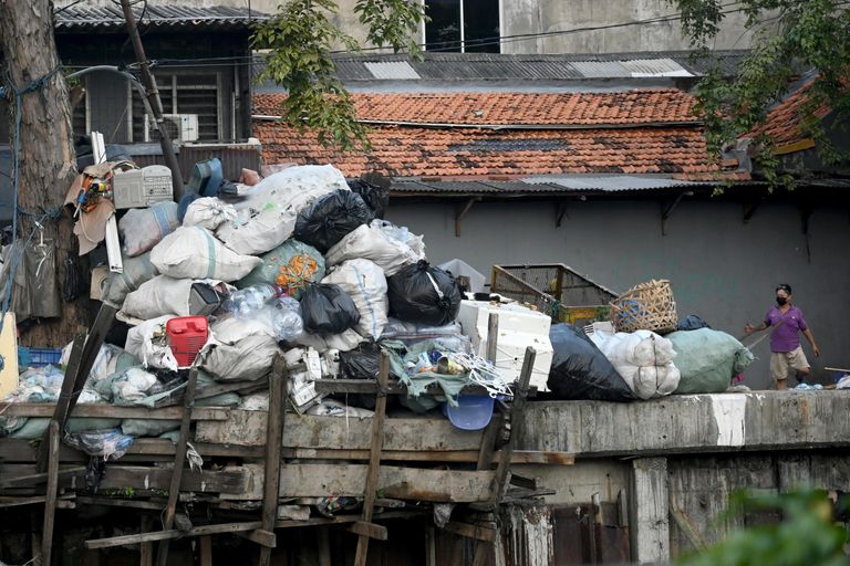 Гора мусора, сложенная вдоль канала, в День Земли в Джакарте Гора мусора, сложенная вдоль канала, в День Земли в Джакарте