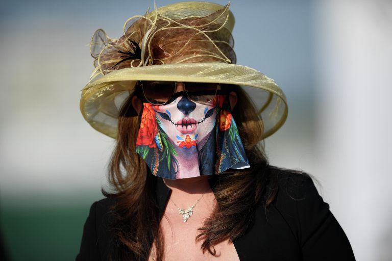 Женщина в защитной маске на скачках Preakness Stakes в Балтиморе 