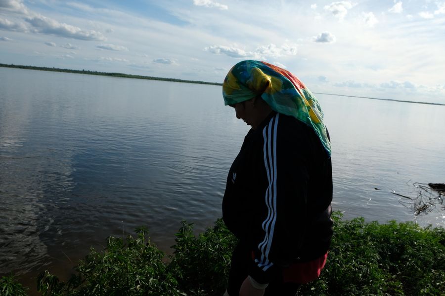 Местная жительница показывает обрушившийся берег Волги Местная жительница показывает обрушившийся берег Волги