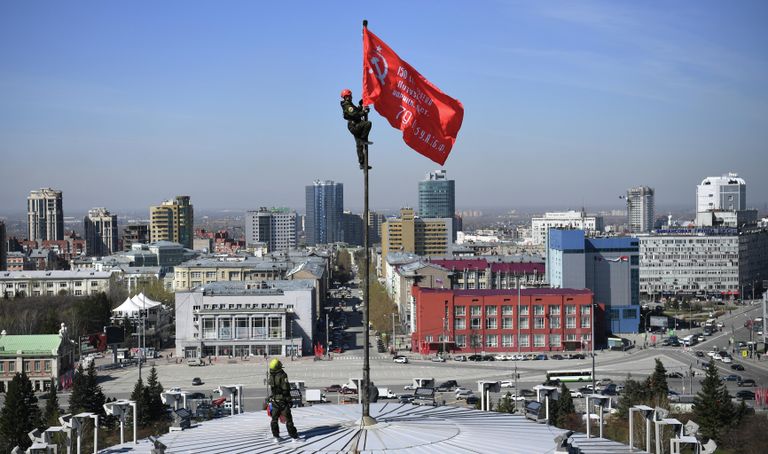 Промышленные альпинисты во время установки копии Знамени Победы над куполом Новосибирского театра оперы и балета (НОВАТ) в центре Новосибирска Промышленные альпинисты во время установки копии Знамени Победы над куполом Новосибирского театра оперы и балета (НОВАТ) в центре Новосибирска