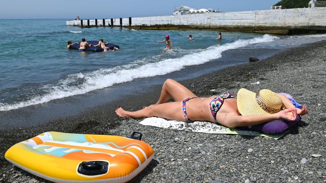Отдыхающие на пляже в Хостинском районе города Сочи