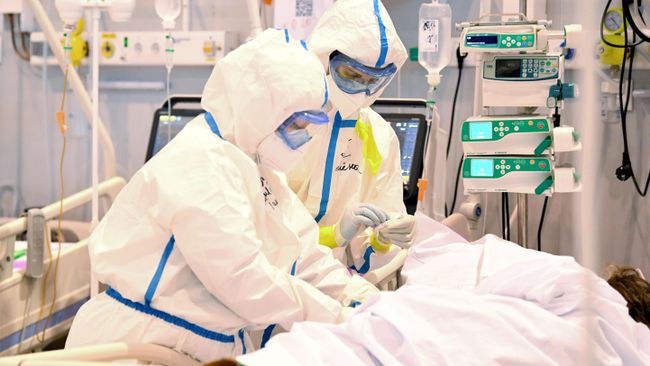 Медицинские работники в палате реанимации и и пациент в палате интенсивной терапии во временном госпитале COVID-19 на ВДНХ в Москве Медицинские работники в палате реанимации и и пациент в палате интенсивной терапии во временном госпитале COVID-19 на ВДНХ в Москве