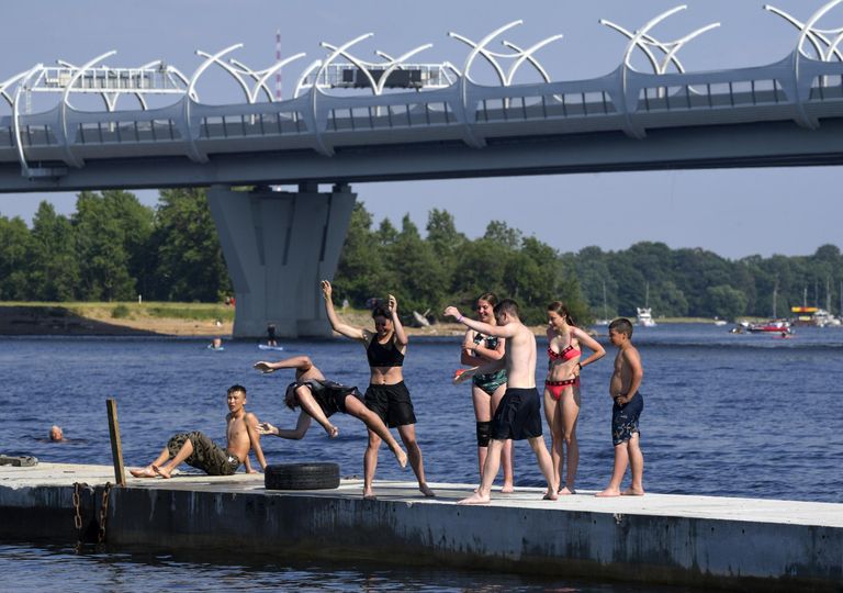 Люди на пирсе неподалеку от пляжа в парке 300-летия Санкт-Петербурга Люди на пирсе неподалеку от пляжа в парке 300-летия Санкт-Петербурга
