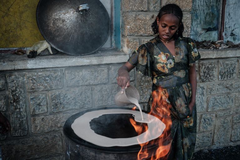 Женщина готовит инджеру, основной продукт Эфиопии - кисло-ферментированные лепешки. Тигрей, Эфиопия Женщина готовит инджеру, основной продукт Эфиопии - кисло-ферментированные лепешки. Тигрей, Эфиопия