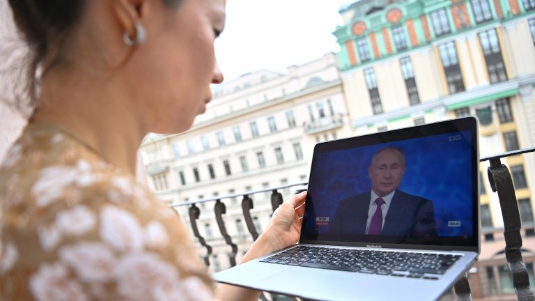 Девушка смотрит трансляцию прямой линии с президентом РФ Владимиром Путиным Девушка смотрит трансляцию прямой линии с президентом РФ Владимиром Путиным