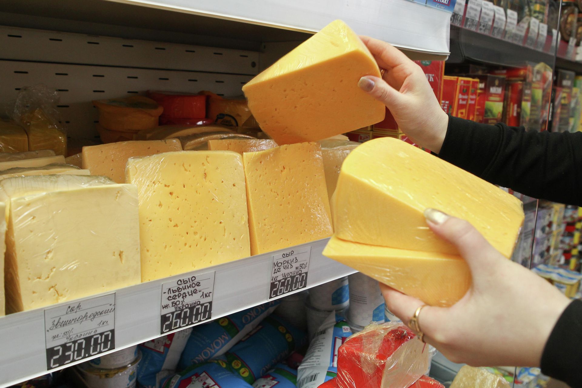Продавец раскладывает фасованный сыр производства Украины на прилавке продуктового магазина Томска Продавец раскладывает фасованный сыр производства Украины на прилавке продуктового магазина Томска - РИА Новости, 1920, 05.07.2021