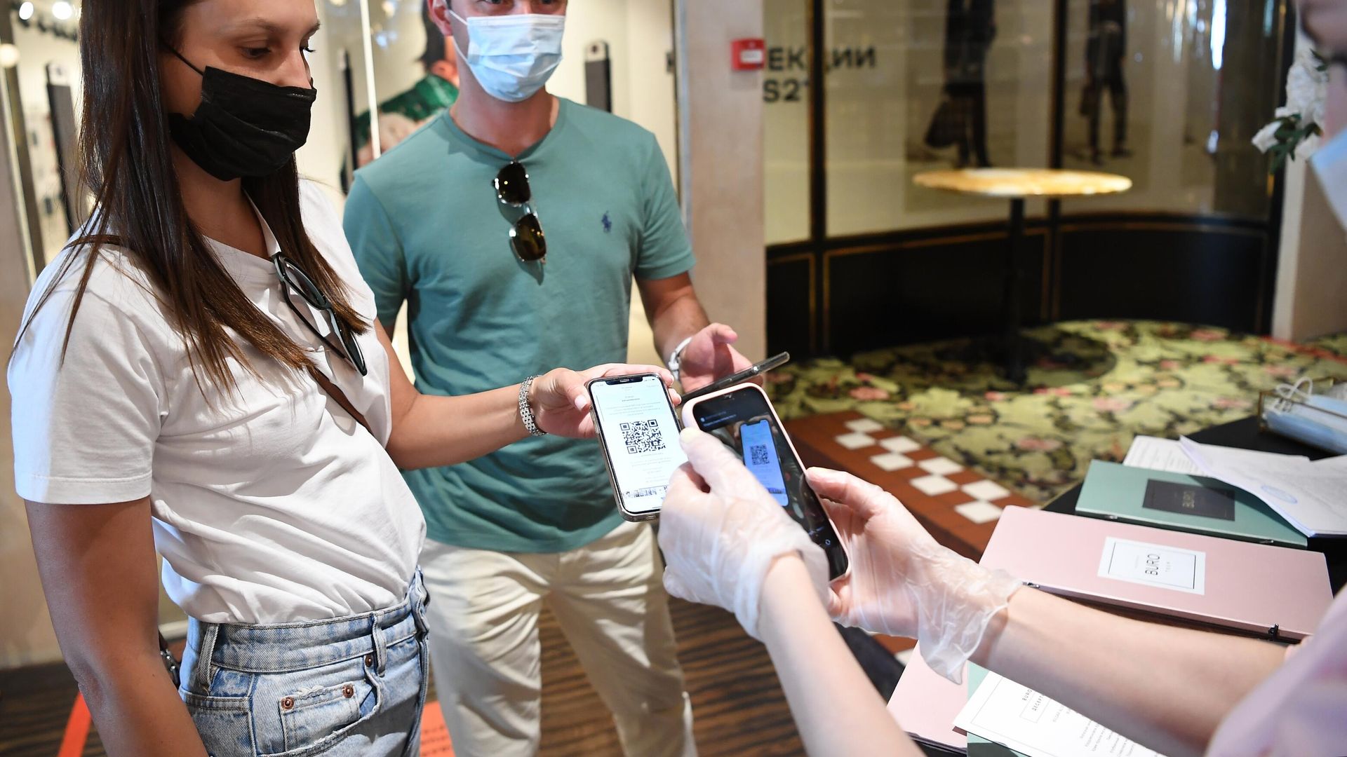 Хостес проверяет наличие и подлинность QR-кода у посетителей Хостес проверяет наличие и подлинность QR-кода у посетителей - РИА Новости, 1920, 30.09.2021