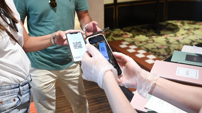 Хостес проверяет наличие и подлинность QR-кода у посетителей