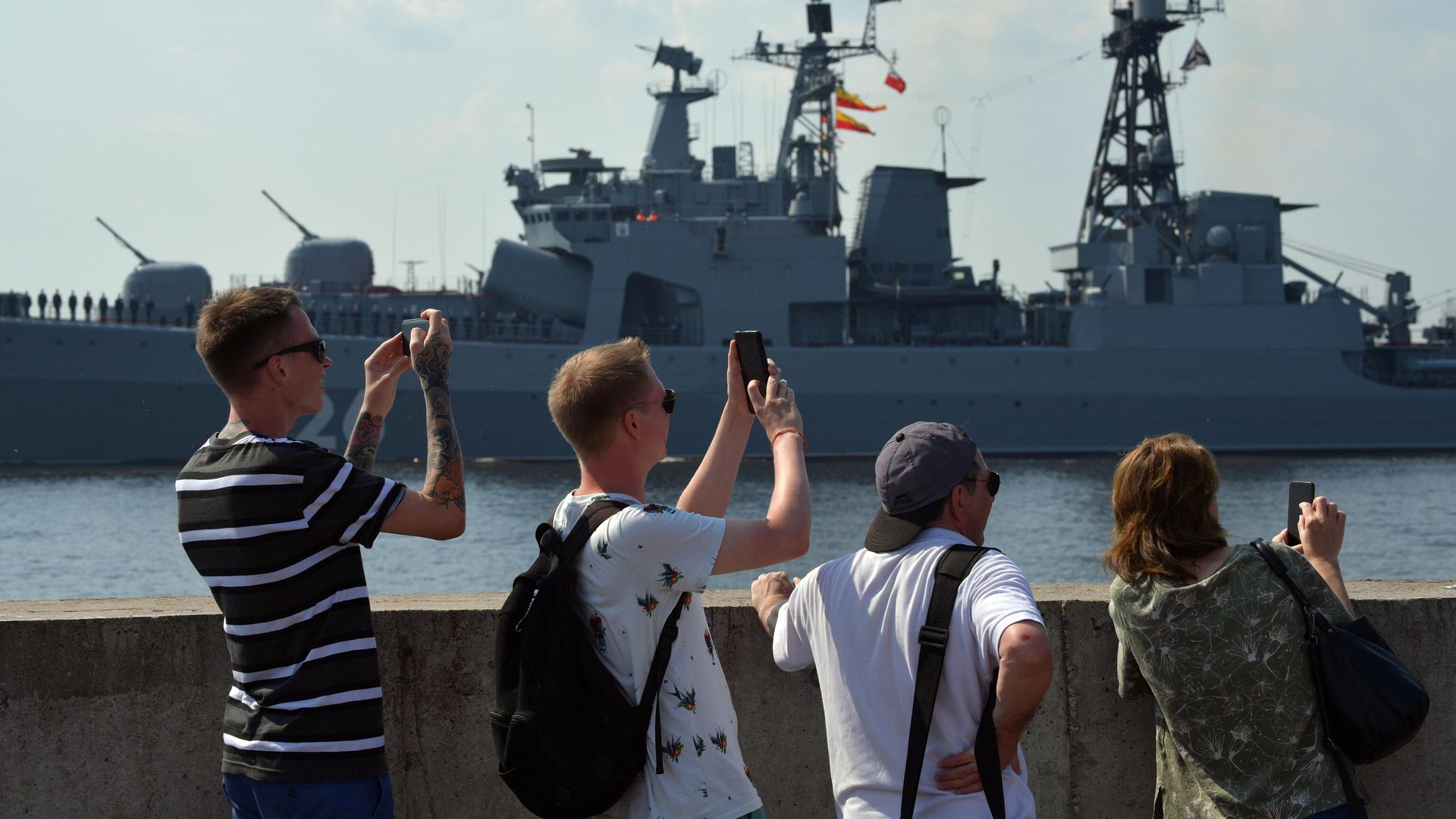 Люди на набережной наблюдают за подготовкой кораблей ВМФ РФ к параду в Кронштадте Люди на набережной наблюдают за подготовкой кораблей ВМФ РФ к параду в Кронштадте - РИА Новости, 1920, 25.07.2021