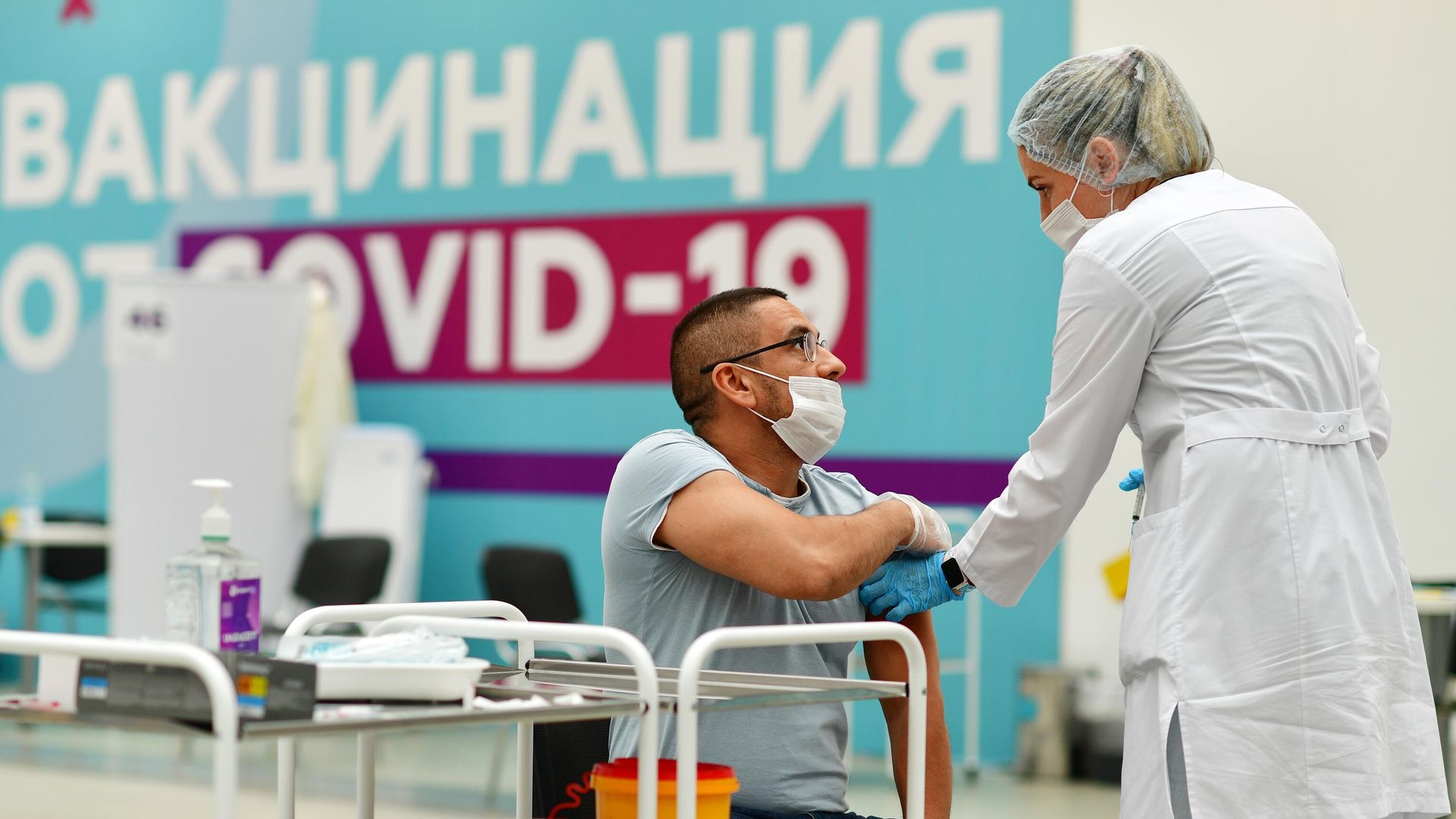 Посетитель делает прививку в центре вакцинации от COVID-19 в Гостином дворе в Москве Посетитель делает прививку в центре вакцинации от COVID-19 в Гостином дворе в Москве - РИА Новости, 1920, 20.10.2021