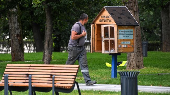 Уличная библиотека в парке Декабрьского восстания рядом со станцией метро Улица 1905 года и рабочий во время благоустройства парка