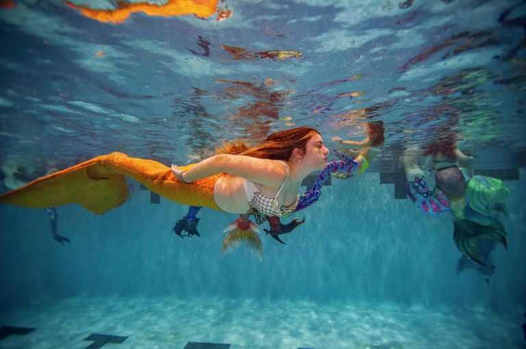Девушка в костюме русалки во время Mermagica Con в водном центре Freedom Aquatic Center в Манассас, штат Вирджиния Девушка в костюме русалки во время Mermagica Con в водном центре Freedom Aquatic Center в Манассас, штат Вирджиния