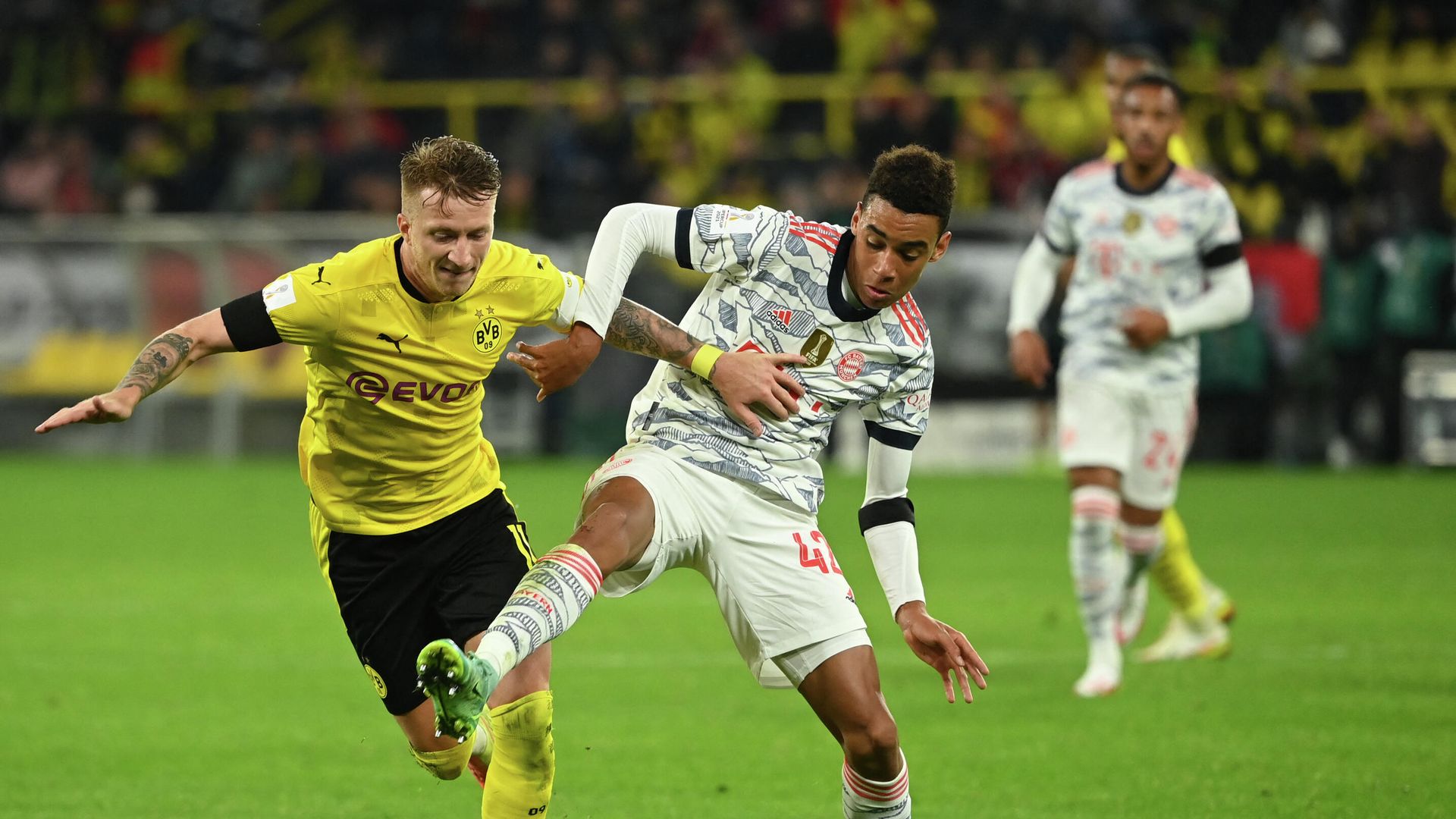 Dortmund's German forward Marco Reus (L) and Bayern Munich's German midfielder Jamal Musiala vie for the ball during the German Supercup football match BVB Borussia Dortmund vs FC Bayern Munich in Dortmund, on August 17, 2021. (Photo by Ina Fassbender / AFP) / DFL REGULATIONS PROHIBIT ANY USE OF PHOTOGRAPHS AS IMAGE SEQUENCES AND/OR QUASI-VIDEO Dortmund's German forward Marco Reus (L) and Bayern Munich's German midfielder Jamal Musiala vie for the ball during the German Supercup football match BVB Borussia Dortmund vs FC Bayern Munich in Dortmund, on August 17, 2021. (Photo by Ina Fassbender / AFP) / DFL REGULATIONS PROHIBIT ANY USE OF PHOTOGRAPHS AS IMAGE SEQUENCES AND/OR QUASI-VIDEO - РИА Новости, 1920, 17.08.2021