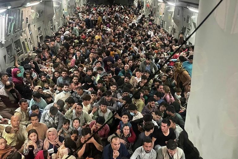 Люди внутри транспортного самолета C-17 Globemaster III ВВС США, перевозящего около 640 афганцев в Катар из Кабула Люди внутри транспортного самолета C-17 Globemaster III ВВС США, перевозящего около 640 афганцев в Катар из Кабула