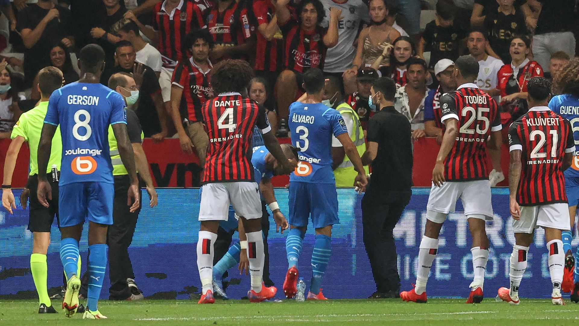 Marseille's Spanish defender Alvaro Gonzalez (C) speaks to Nice's supporters as Marseille's French midfielder Dimitri Payet (C-L) picks up a bottle of water on the pitch during the French L1 football match between OGC Nice and Olympique de Marseille (OM) at the Allianz Riviera stadium in Nice, southern France on August 22, 2021. - The French Ligue 1 game between Nice and Marseille was halted on August 22, 2021, when fans of the home side invaded the pitch and angrily confronted opposing player Dimitri Payet. An AFP journalist at the game said trouble flared in the 75th minute when Marseille star Payet, who had been targeted by plastic bottles every time he took a corner, lobbed one back into the stands. (Photo by Valery HACHE / AFP) Marseille's Spanish defender Alvaro Gonzalez (C) speaks to Nice's supporters as Marseille's French midfielder Dimitri Payet (C-L) picks up a bottle of water on the pitch during the French L1 football match between OGC Nice and Olympique de Marseille (OM) at the Allianz Riviera stadium in Nice, southern France on August 22, 2021. - The French Ligue 1 game between Nice and Marseille was halted on August 22, 2021, when fans of the home side invaded the pitch and angrily confronted opposing player Dimitri Payet. An AFP journalist at the game said trouble flared in the 75th minute when Marseille star Payet, who had been targeted by plastic bottles every time he took a corner, lobbed one back into the stands. (Photo by Valery HACHE / AFP) - РИА Новости, 1920, 23.08.2021