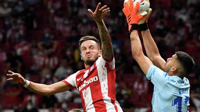 Villarreal's Argentinian goalkeeper Geronimo Rulli (R) makes a save while challenged by Atletico Madrid's Spanish midfielder Saul Niguez during the Spanish League football match between Club Atletico de Madrid and Villarreal CF at the Wanda Metropolitano stadium in Madrid on August 29, 2021. (Photo by PIERRE-PHILIPPE MARCOU / AFP)