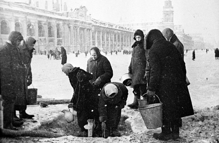 Жители блокадного Ленинграда набирают воду, появившуюся после артобстрела в пробоинах в асфальте на Невском проспекте Жители блокадного Ленинграда набирают воду, появившуюся после артобстрела в пробоинах в асфальте на Невском проспекте