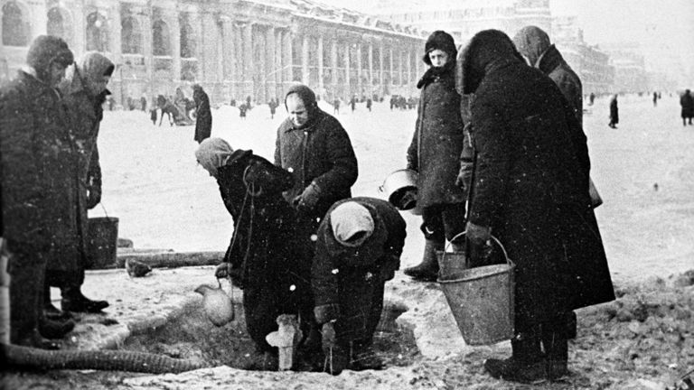 Жители блокадного Ленинграда набирают воду, появившуюся после артобстрела в пробоинах в асфальте на Невском проспекте Жители блокадного Ленинграда набирают воду, появившуюся после артобстрела в пробоинах в асфальте на Невском проспекте