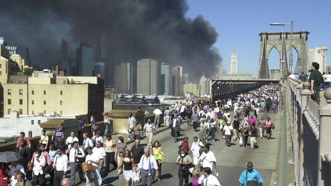 Люди бегут по Бруклинскому мосту во время теракта 11 сентября 2001 в Нью-Йорке