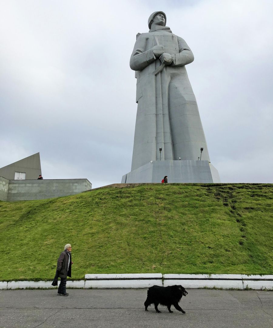 Женщина гуляет с собакой у подножия мемориала защитникам Советского Заполярья в Мурманске, на сопке Зеленый мыс Женщина гуляет с собакой у подножия мемориала защитникам Советского Заполярья в Мурманске, на сопке Зеленый мыс