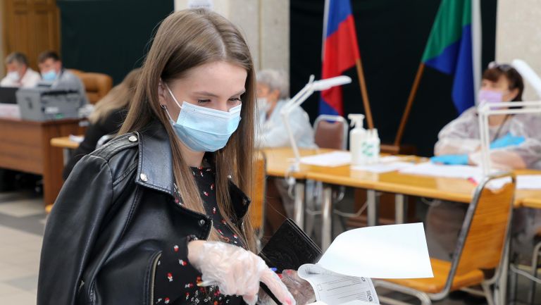 Девушка голосует на избирательном участке в Хабаровске Девушка голосует на избирательном участке в Хабаровске