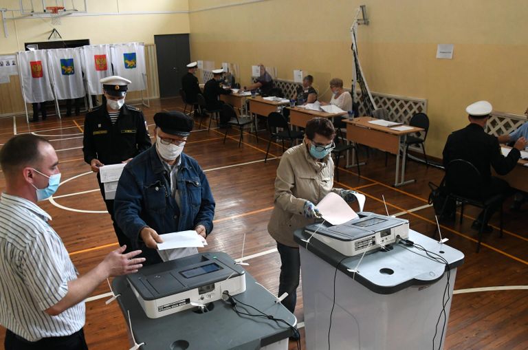 Люди голосуют на избирательном участке во Владивостоке Люди голосуют на избирательном участке во Владивостоке