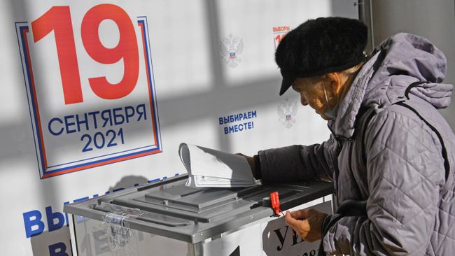 Пожилая женщина во время голосования на избирательном участке