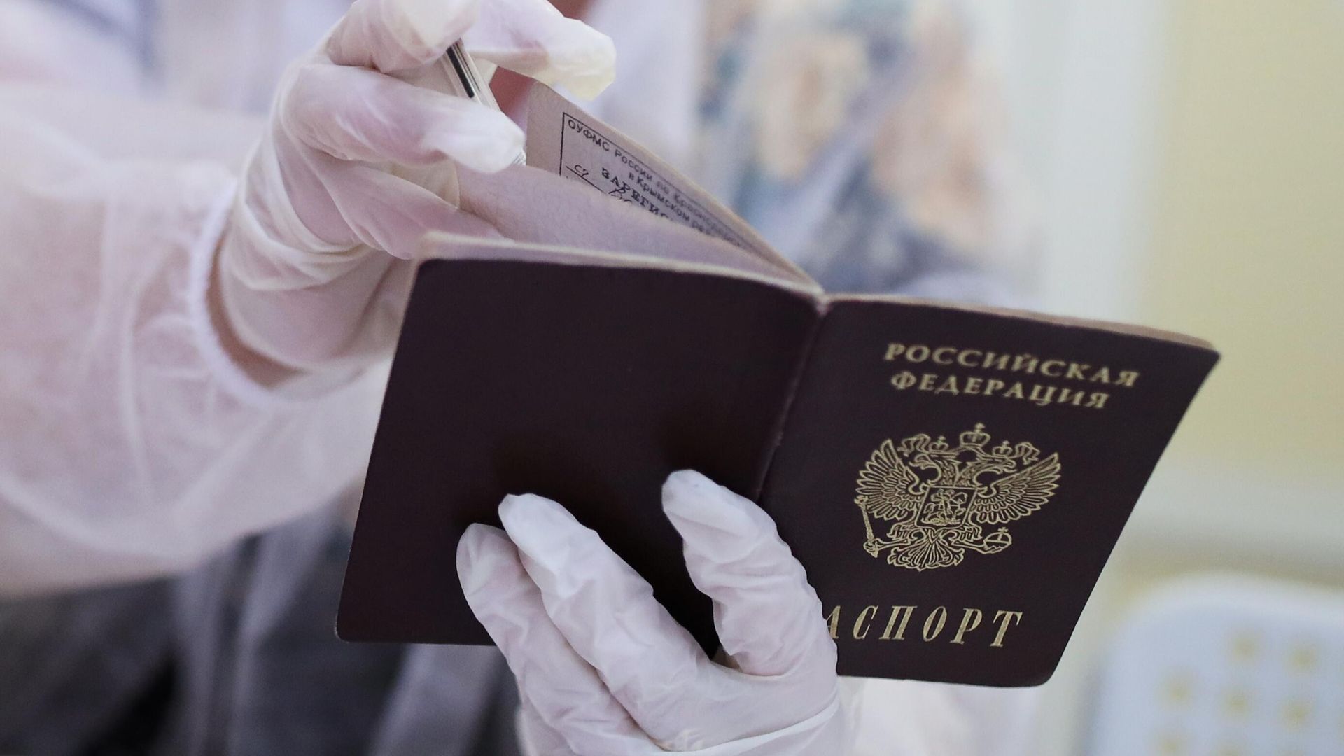 Сотрудница избирательного участка смотрит паспорт избирателя перед выдачей бюллетеня для голосования на выборах депутатов Государственной Думы РФ Сотрудница избирательного участка смотрит паспорт избирателя перед выдачей бюллетеня для голосования на выборах депутатов Государственной Думы РФ - РИА Новости, 1920, 26.09.2021
