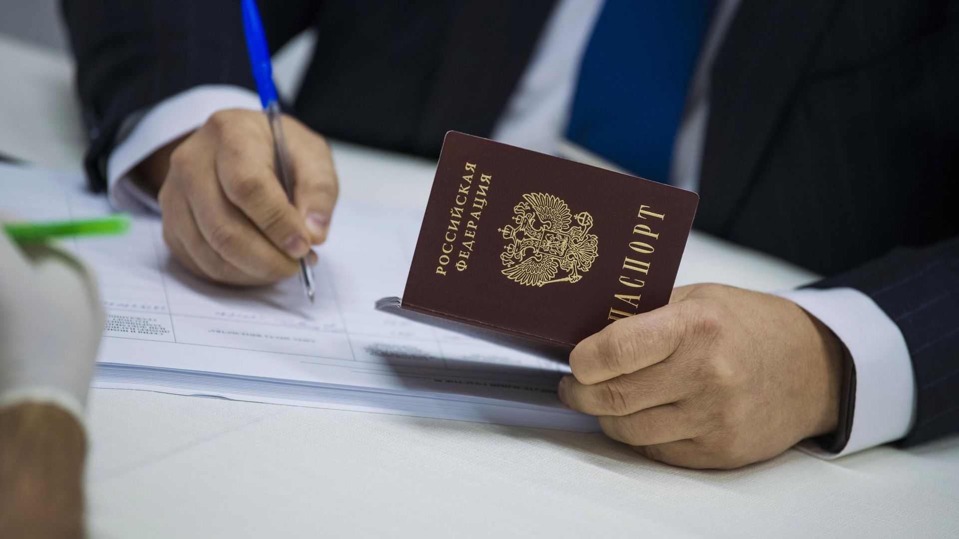 Мужчина с паспортом гражданина России заполняет документ Мужчина с паспортом гражданина России заполняет документ - РИА Новости, 1920, 08.05.2022