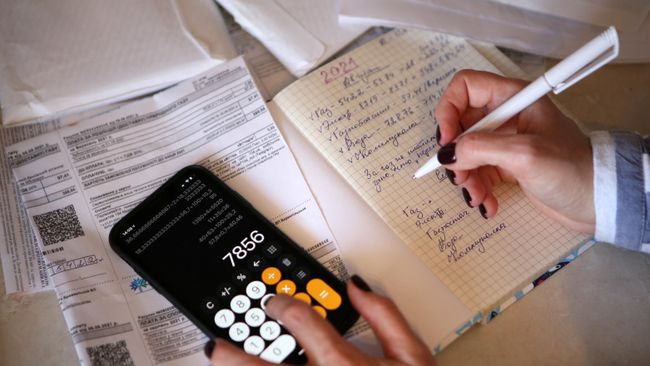 Девушка подсчитывает коммунальные платежи