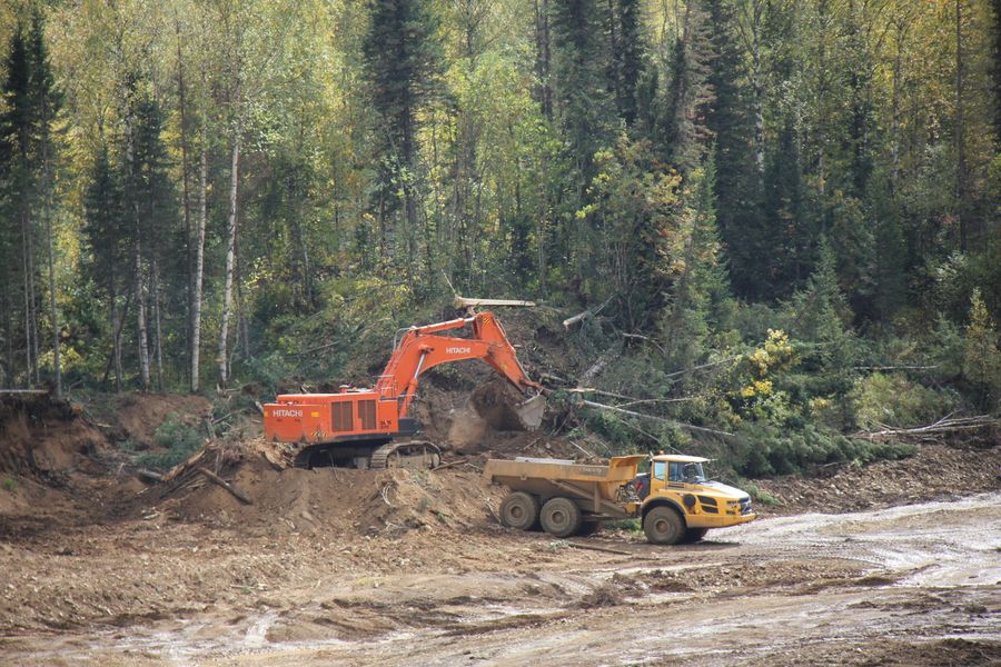 Экскаватор сдирает ковшом плодородный слой почвы Экскаватор сдирает ковшом плодородный слой почвы