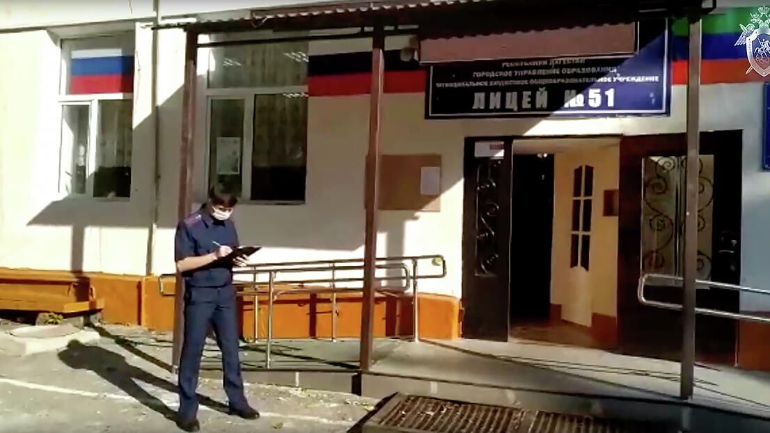 Сотрудник СК РФ у школы №51 Махачкалы, где произошло убийство учащегося. Кадр видео Сотрудник СК РФ у школы №51 Махачкалы, где произошло убийство учащегося. Кадр видео - РИА Новости, 1920, 11.10.2021