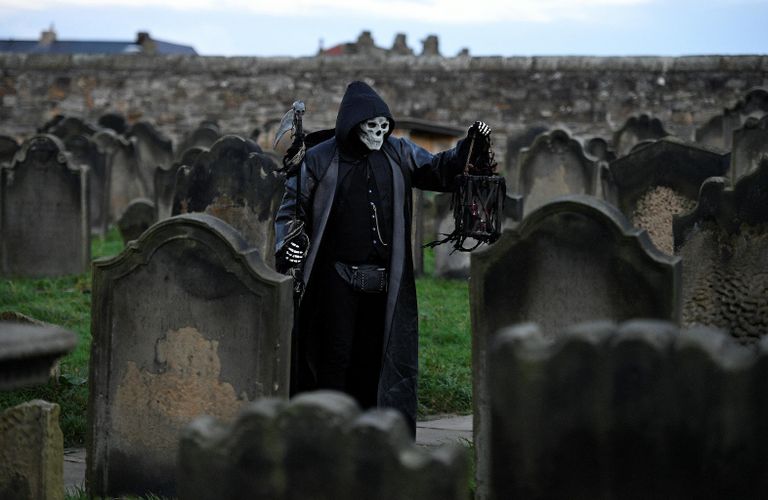 Участник фестиваля Whitby Goth Weekend среди надгробий в церкви Святой Марии в Уитби, северная Англия Участник фестиваля Whitby Goth Weekend среди надгробий в церкви Святой Марии в Уитби, северная Англия
