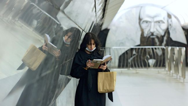 Девушка читает книгу на станции московского метрополитена Достоевская Девушка читает книгу на станции московского метрополитена Достоевская
