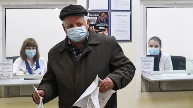 Пожилой мужчина в офисе управляющей компании оплачивает услуги ЖКХ Пожилой мужчина в офисе управляющей компании оплачивает услуги ЖКХ