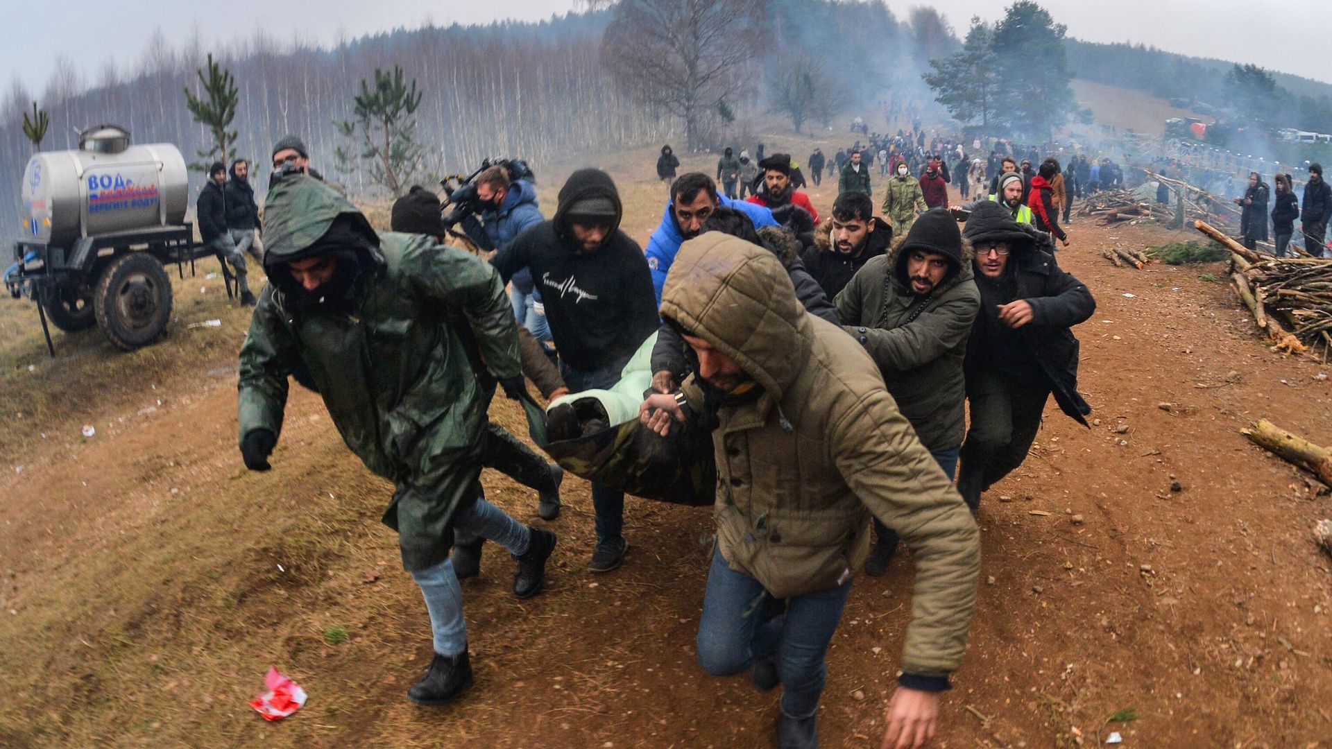 Мужчины несут к машине скорой помощи женщину в лагере нелегальных мигрантов на белорусско-польской границе Мужчины несут к машине скорой помощи женщину в лагере нелегальных мигрантов на белорусско-польской границе - РИА Новости, 1920, 13.11.2021