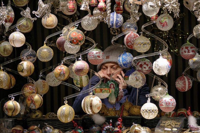 Продавец разговаривает по телефону на рождественской ярмарке в Вене, Австрия Продавец разговаривает по телефону на рождественской ярмарке в Вене, Австрия