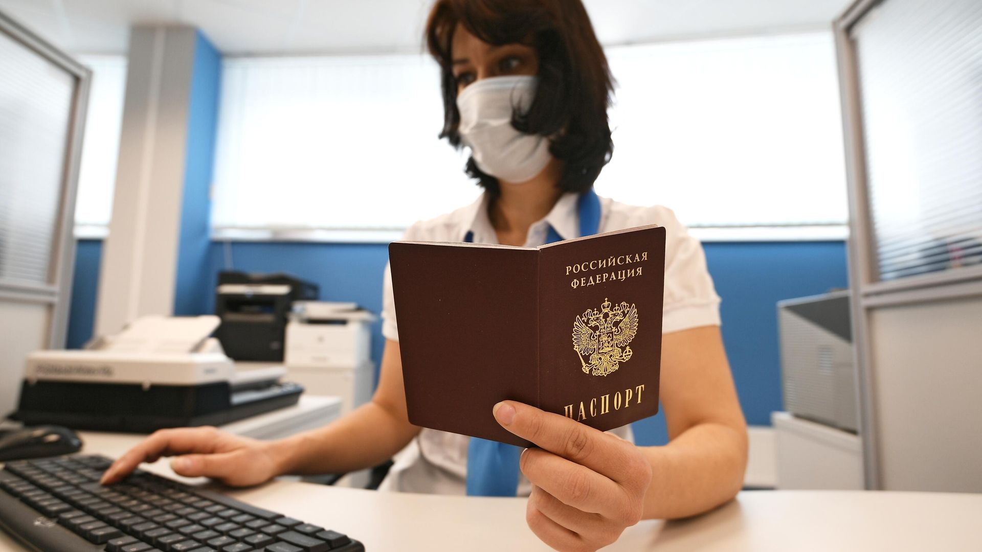 Сотрудник ПФР держит в руках паспорт РФ Сотрудник ПФР держит в руках паспорт РФ - РИА Новости, 1920, 26.12.2021