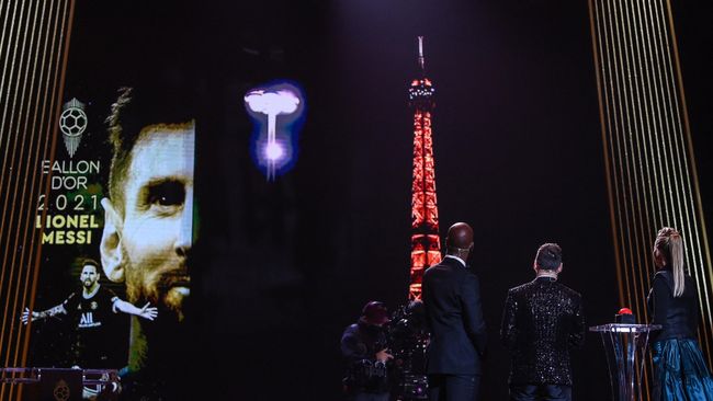 Ballon d'Or award recipient Paris Saint-Germain's Argentine forward Lionel Messi (2R), and evening hosts French-British journalist Sandy Heribert (R) and Ivorian former football player Didier Drogba (3R) watch a broadcast of a display at the Trocadero Esplanade and the Eiffel Tower in honour of Messi's award during the 2021 Ballon d'Or France Football award ceremony at the Theatre du Chatelet in Paris on November 29, 2021. (Photo by FRANCK FIFE / AFP) Ballon d'Or award recipient Paris Saint-Germain's Argentine forward Lionel Messi (2R), and evening hosts French-British journalist Sandy Heribert (R) and Ivorian former football player Didier Drogba (3R) watch a broadcast of a display at the Trocadero Esplanade and the Eiffel Tower in honour of Messi's award during the 2021 Ballon d'Or France Football award ceremony at the Theatre du Chatelet in Paris on November 29, 2021. (Photo by FRANCK FIFE / AFP)