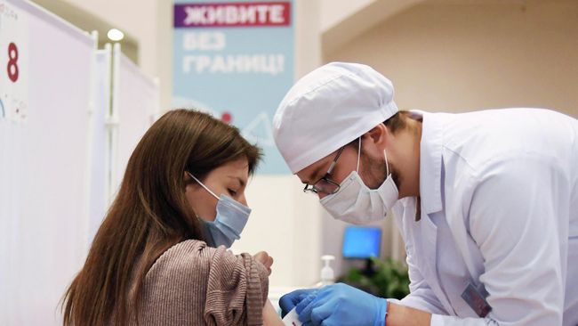 Девушка делает прививку в пункте вакцинации от COVID-19