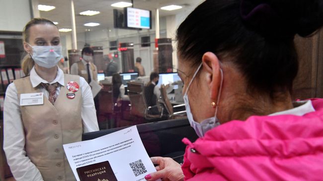 Женщина получает распечатанный бумажный QR-код в многофункциональном центре госуслуг Мои документы в Москве
