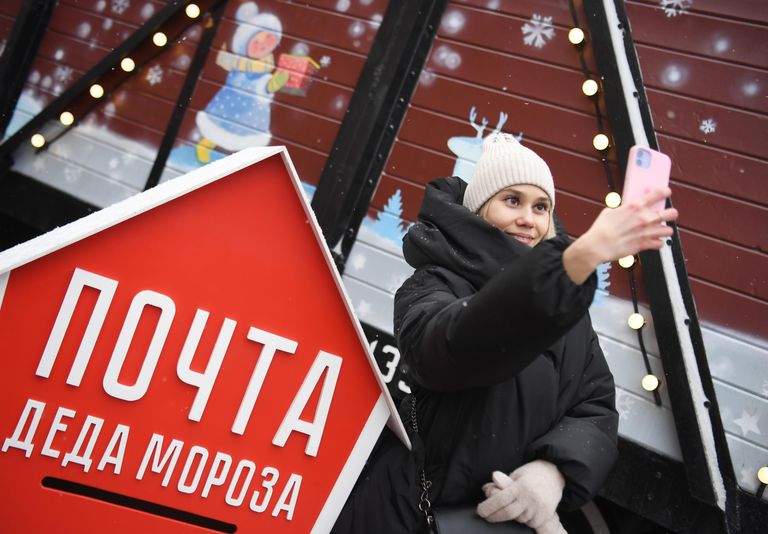 Девушка фотографируется на фоне сказочного поезда Деда Мороза, прибывшего на железнодорожный вокзал в Казань Девушка фотографируется на фоне сказочного поезда Деда Мороза, прибывшего на железнодорожный вокзал в Казань