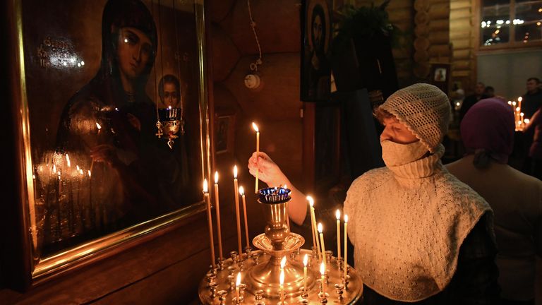 Женщина ставит свечу во время ночной Рождественской службы в православной Знаменской церкви в городе Дивногорске Красноярского края Женщина ставит свечу во время ночной Рождественской службы в православной Знаменской церкви в городе Дивногорске Красноярского края