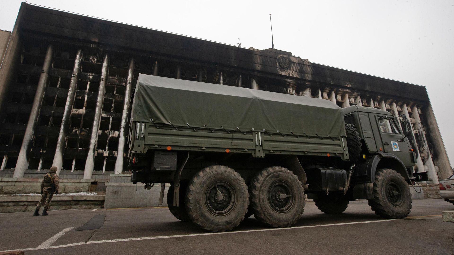 Военный автомобиль у сгоревшего здания акимата в Алма-Ате Военный автомобиль у сгоревшего здания акимата в Алма-Ате - РИА Новости, 1920, 12.01.2022