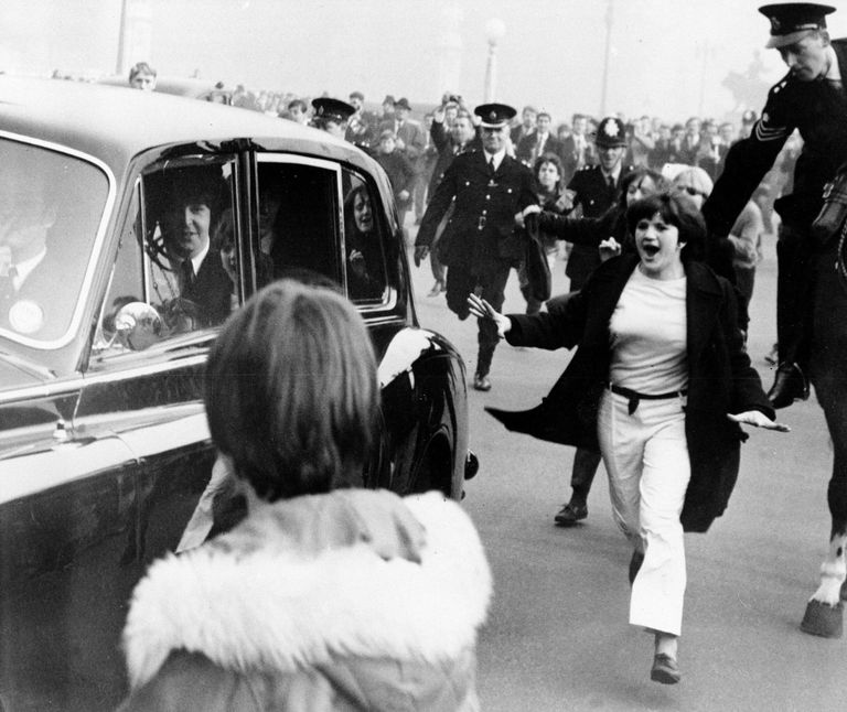 Автомобиль с участниками группы The Beatles в окружении фанатов в Лондоне Автомобиль с участниками группы The Beatles в окружении фанатов в Лондоне