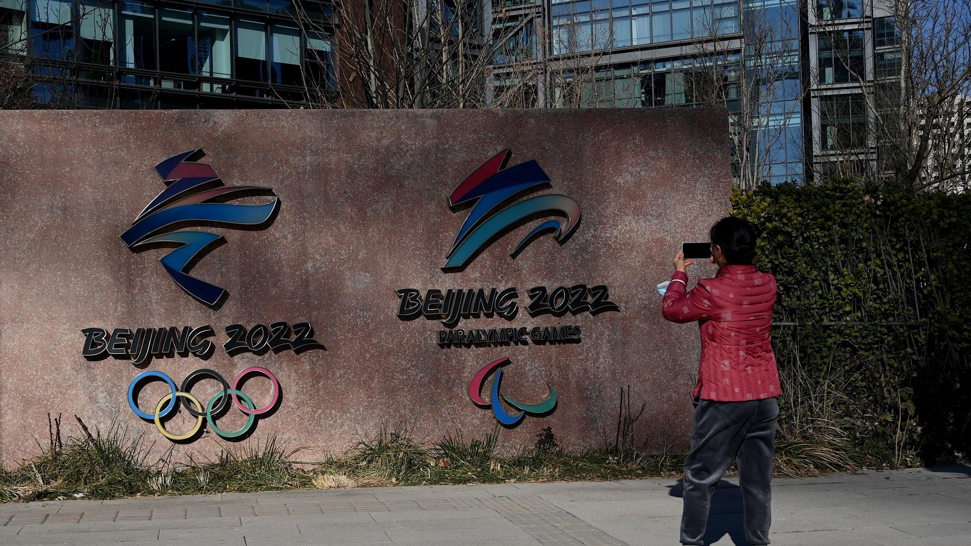 A woman takes a photo of the logos of Beijing 2022 Winter Olympics and Paralympic Winter Games in Shougang Park, one of the sites for the Olympics, in Beijing on December 7, 2021. (Photo by Noel Celis / AFP) A woman takes a photo of the logos of Beijing 2022 Winter Olympics and Paralympic Winter Games in Shougang Park, one of the sites for the Olympics, in Beijing on December 7, 2021. (Photo by Noel Celis / AFP) - РИА Новости, 1920, 14.01.2022