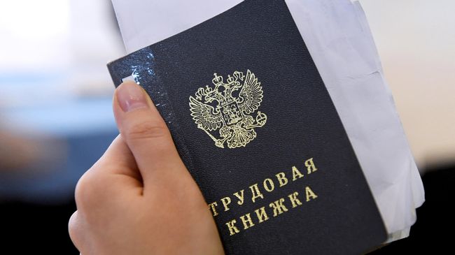 Трудовая книжка в руке у посетителя ярмарки вакансий