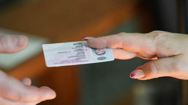 Мужчина получает водительское удостоверение в отделении ГИБДД в Москве Мужчина получает водительское удостоверение в отделении ГИБДД в Москве